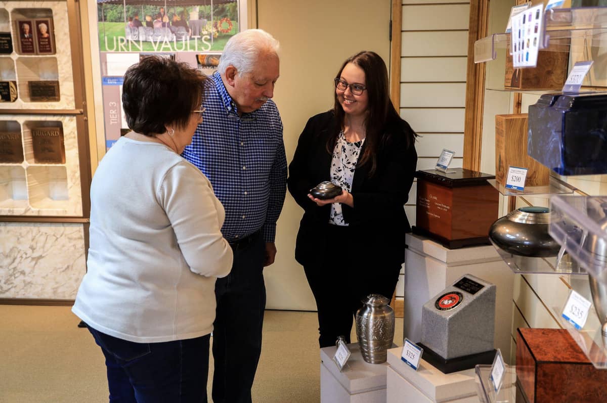 Two seniors looking at urns with a saleswoman