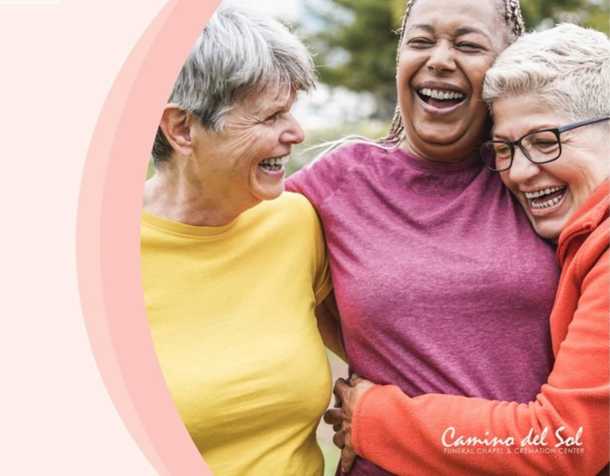 Three senior women laughing and hugging