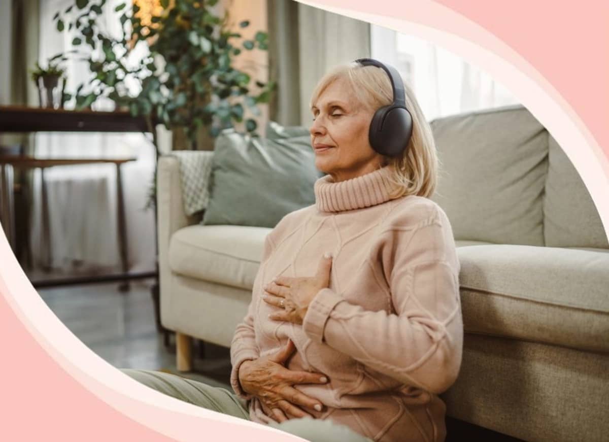 A senior woman wearing headphones and meditating